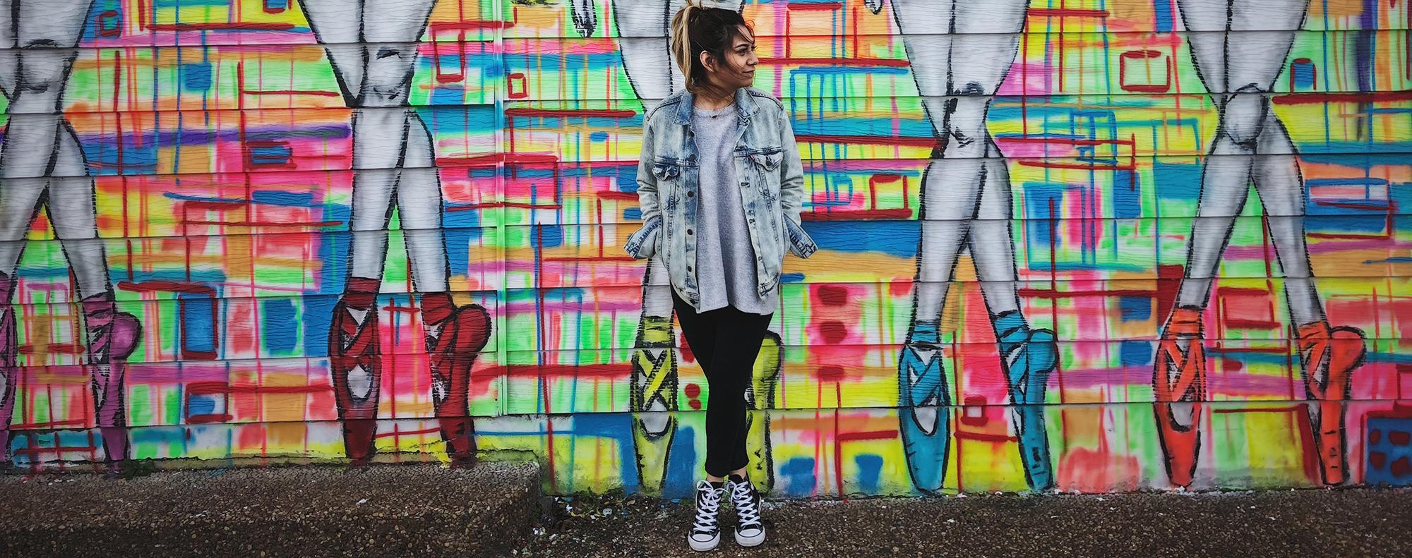 Woman standing against graffiti art